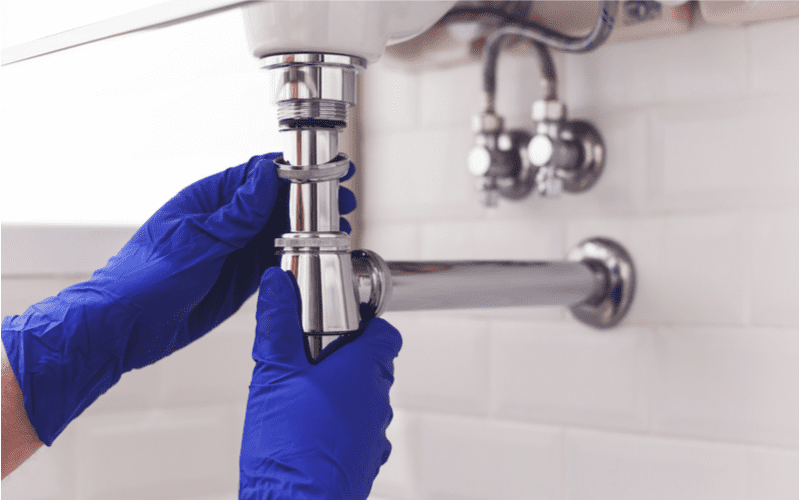 Rørlegger som fikser røroppheng på vaskeservant